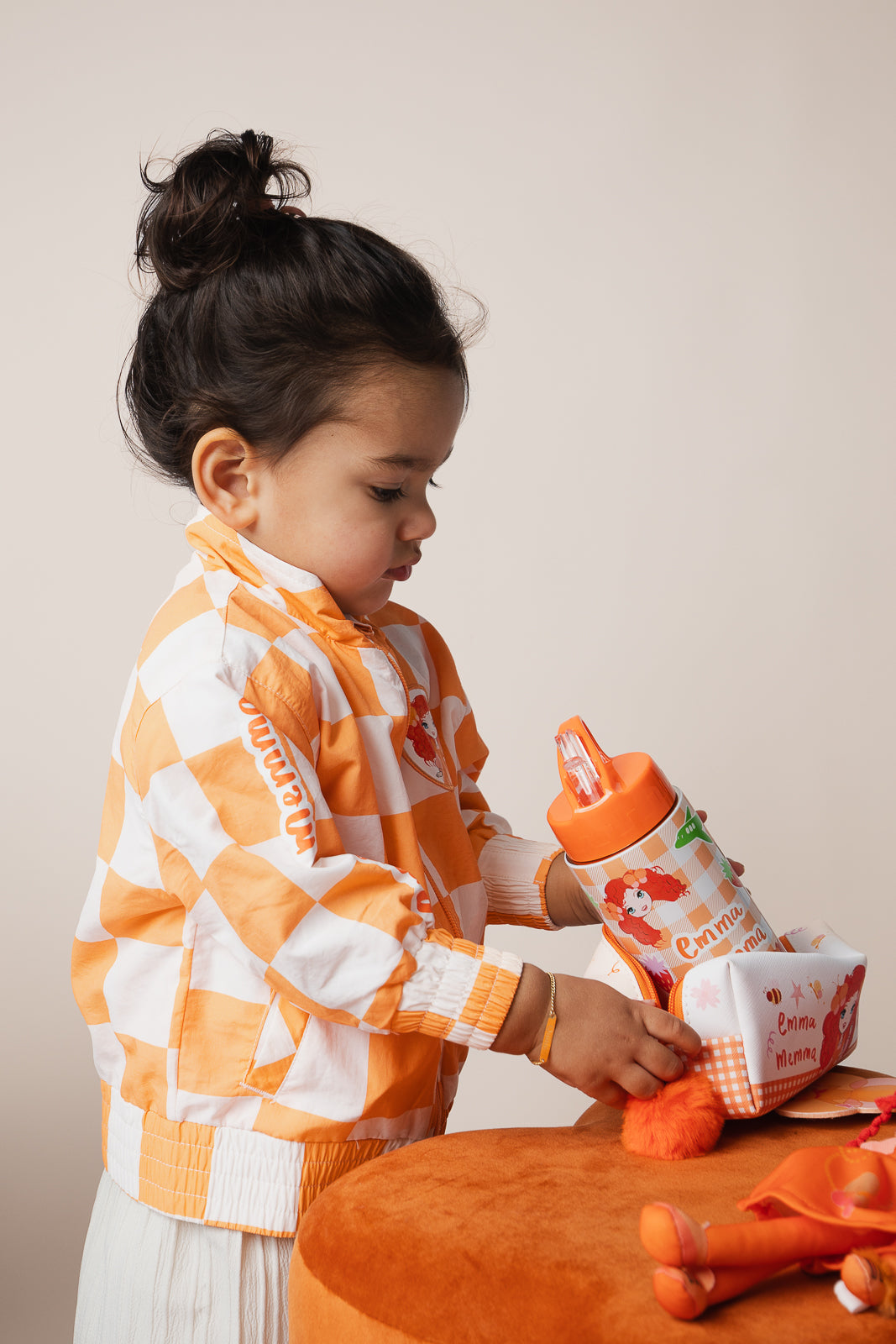 Child holding Emma Memma Gingham Drink Bottle smiling