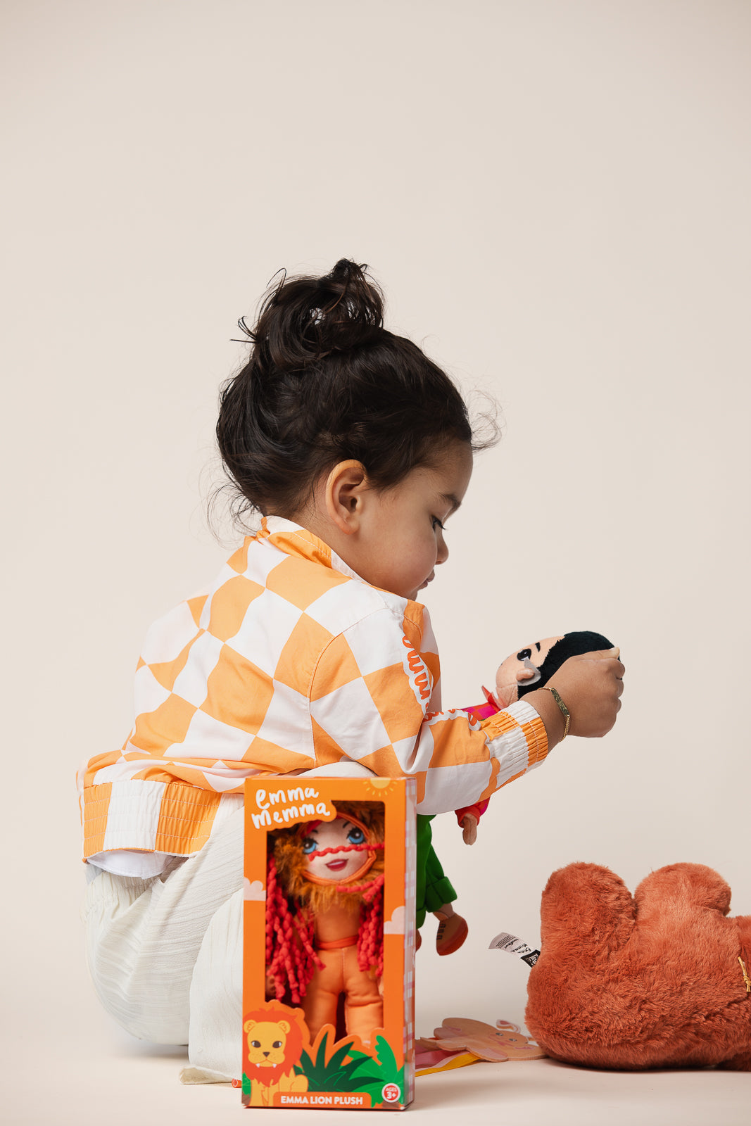 Emma Memma Lion plush bag tag being held by a child