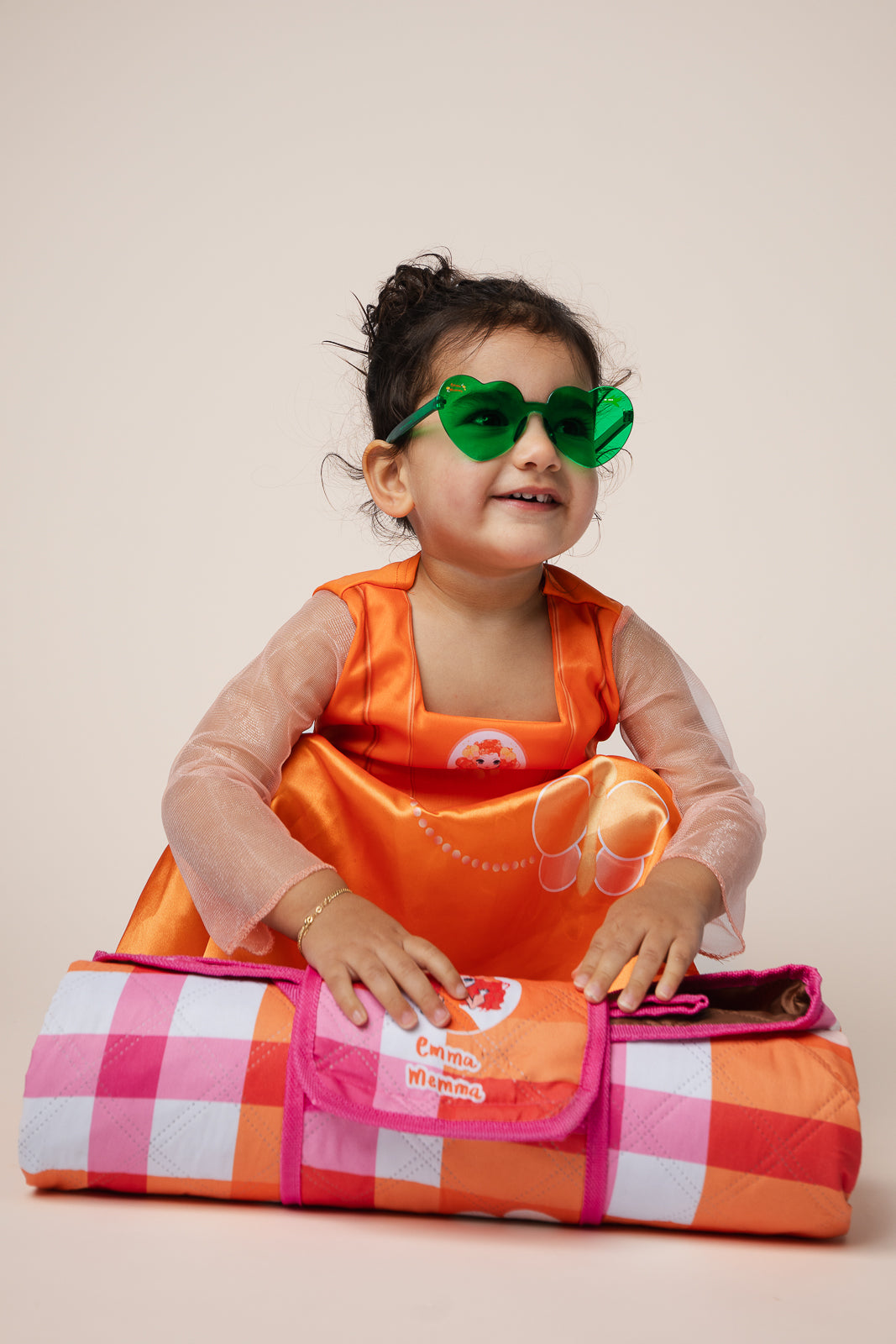Child wearing Emma Memma green heart shaped sunglasses smiling