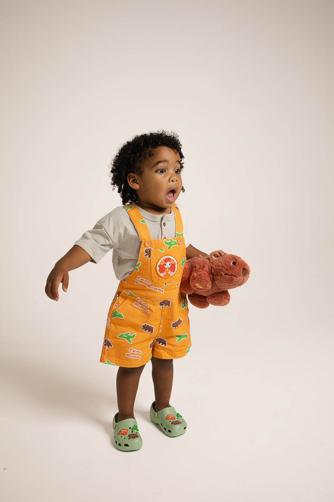 Child wearing Emma Memma overalls jumping and playing